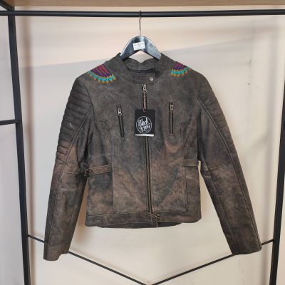 une veste en cuir suspendue à un portant dans un magasin de vêtements
