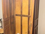 a wooden armoire in the corner of a room