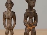 une paire de figurines en bois représentant un homme et une femme, posées sur une table