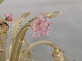 a glass chandelier with pink flowers in it
