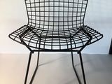 black wire chair in a white room with a white wall