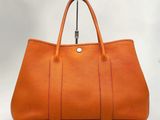 un grand sac fourre-tout en cuir orange sur fond blanc