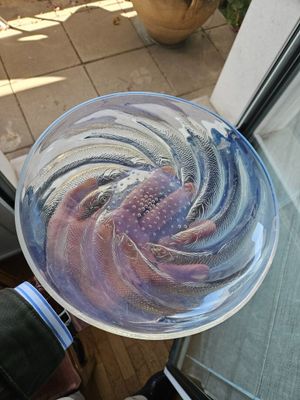 une assiette en verre contenant du poisson, posée sur une table