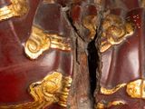 a close up of a red and gold statue with a cross on it