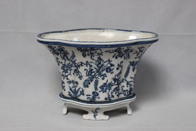 une jardinière bleue et blanche posée sur un support