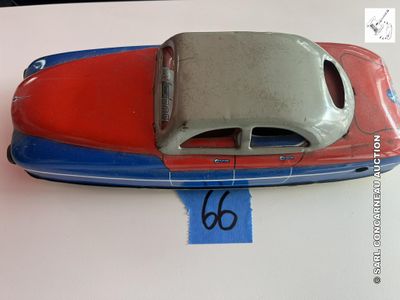 un bateau jouet rouge et bleu posé sur une table blanche