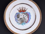 une image représentant une assiette sur laquelle figurent des armoiries et une couronne