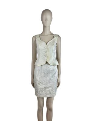 the mannequin is wearing a white dress and a white jacket