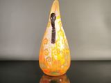 a yellow and white vase sitting on a black table