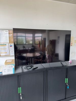 une télévision à écran plat posée sur un meuble dans une pièce