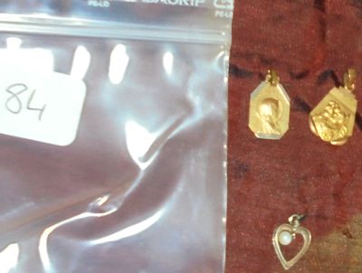 un sac contenant des bijoux en or et une paire de boucles d'oreilles posés sur une table