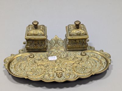 pair of antique brass inkwells on a tray