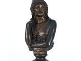 un buste antique en bronze représentant une femme coiffée d'un chapeau