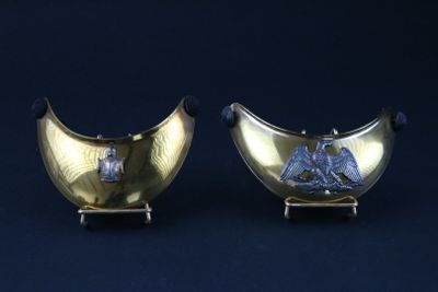 pair of silver and gold vases with birds on them on a stand