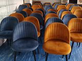 des rangées de fauteuils en velours bleu et orange dans une pièce où se trouve un piano