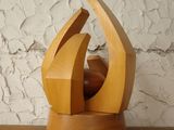 a wooden sculpture sitting on a shelf next to a wall