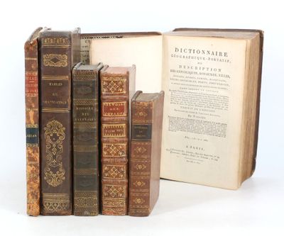 plusieurs vieux livres posés les uns sur les autres sur une surface blanche