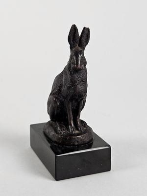 statue d'un lapin assis sur un socle en marbre, sur fond blanc