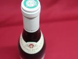 a bottle of syrup sitting on a red cloth