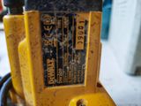 a close up of a yellow drill on the ground