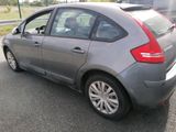 a grey car that is parked on the side of the road