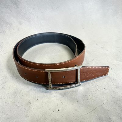 un gros plan sur une ceinture en cuir marron dotée d'une boucle argentée