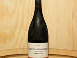une bouteille de vin posée sur un tonneau en bois