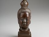a bronze statue of a woman with a bird on her head