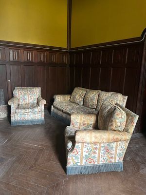 des canapés et des fauteuils dans une pièce avec des lambris et une cheminée