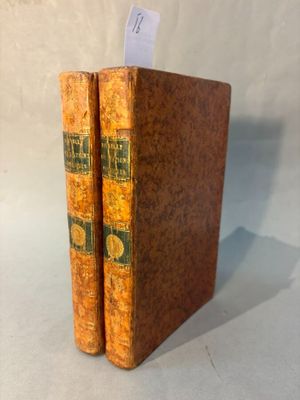 un vieux livre posé sur une table à côté d'une feuille de papier