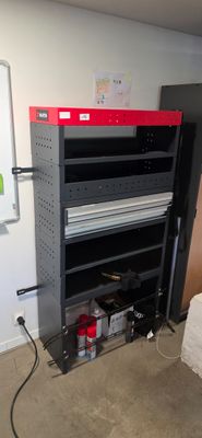a black and red shelf in the corner of a room