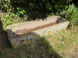 un banc en béton posé au milieu de la pelouse