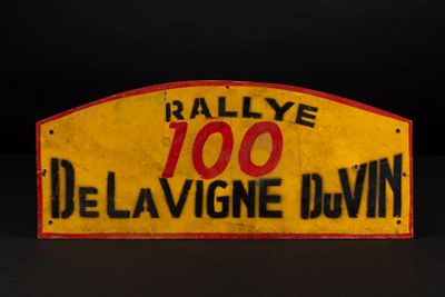 un panneau jaune et rouge sur lequel on peut lire « Rallye 100 Delavigne d'Inn »