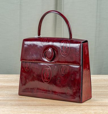 an image of a red purse on a wooden table
