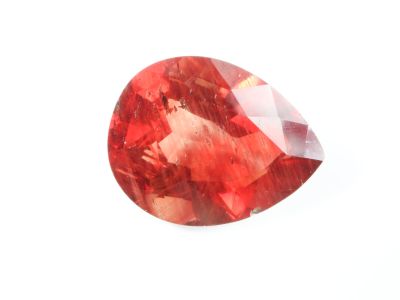 un gros plan d'un diamant rouge sur une surface blanche