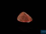 un gros plan d'un morceau de roche rouge sur une surface noire