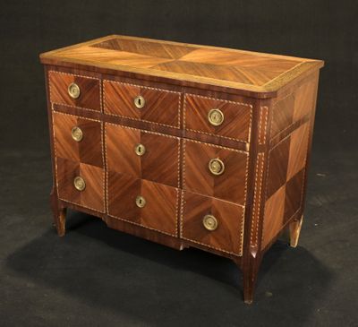 une commode ancienne avec un plateau en bois et des ferrures en laiton