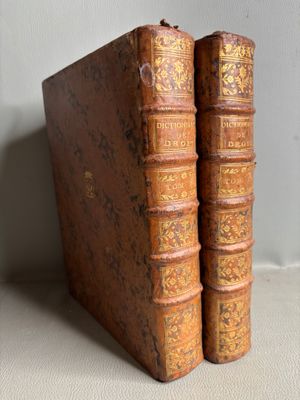 two old books sitting on top of a table next to each other