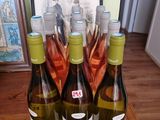 trois bouteilles de vin sont posées sur une table, à côté d'une photo encadrée