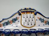 a large blue and white bowl with a gold handle
