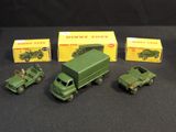 three toy army trucks are sitting next to each other on a black surface