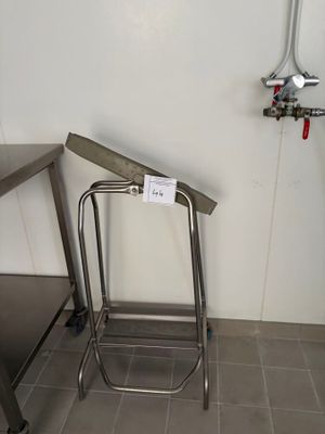 une table en acier inoxydable et un tabouret en métal dans une cuisine