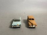 two toy cars sitting next to each other on a table