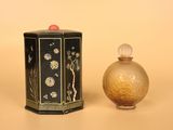 une image représentant un petit vase noir et doré à côté d'un autre petit vase noir et doré