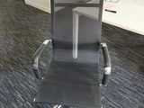 a black chair that is sitting in the middle of a room