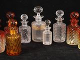 plusieurs bouteilles en verre de différentes couleurs posées les unes à côté des autres sur une surface noire