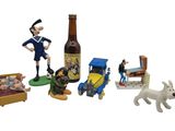 toy figurines of a man, a dog, a bed, and a bottle of beer