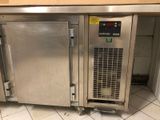 a large stainless steel freezer sitting in the middle of a tiled floor
