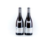 two bottles of red wine sitting next to each other on a white surface