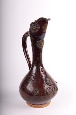 un vase brun posé sur une surface blanche